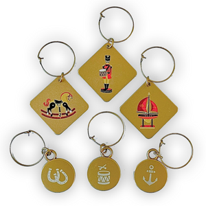 Wine charms with 2012 tin soldier, 2013 rocking horse, and 2014 sailboat, as well as horseshoe, drum, and anchor branded wine charms.